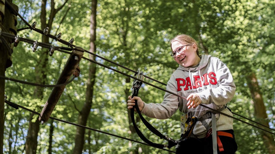 Pige Klatrer I Traer Paa Camp Landscape