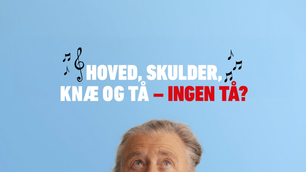 På billedet ses toppen af hovedet på en mand, der kigger op på teksten: Hoved, skulder, knæ tå og - ingen tå.